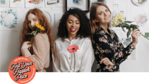 three girls stand with flower stems
