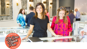 A woman behind a jewelry display counter