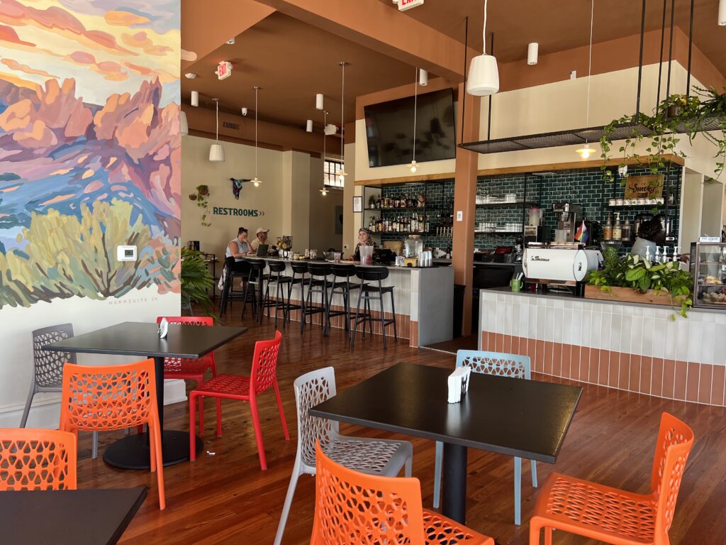 A contemporary coffee shop setting with tables and a bar in Brookland Park Richmond