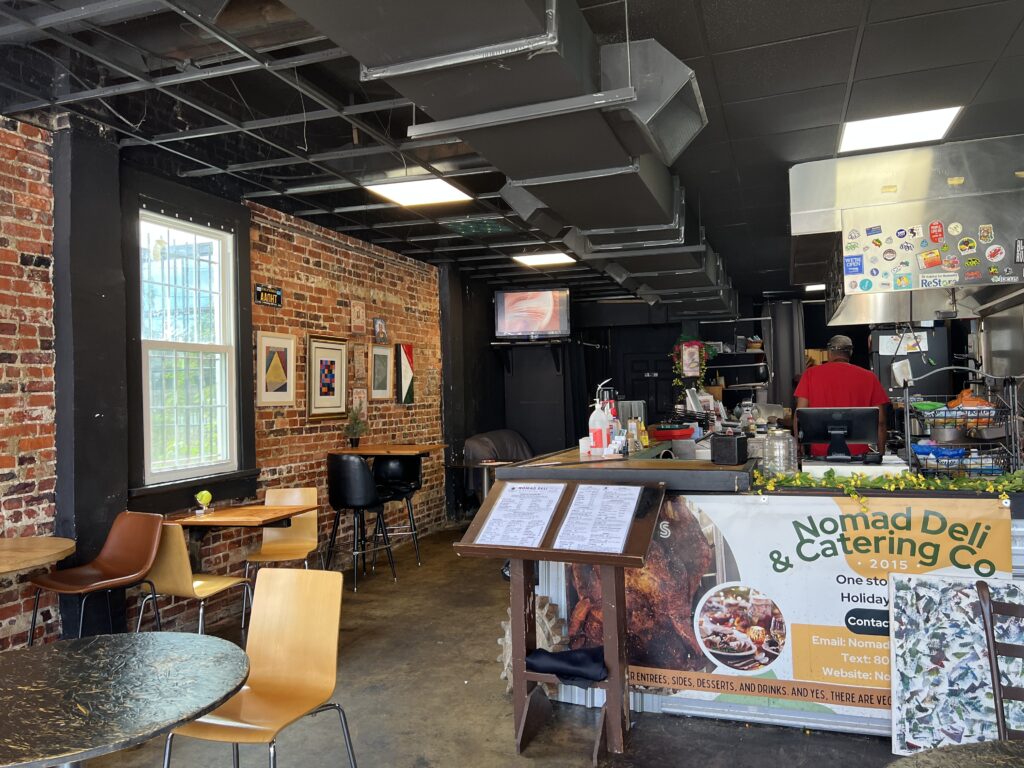A brick wall and a deli counter with tables in Bookland Park Richmond