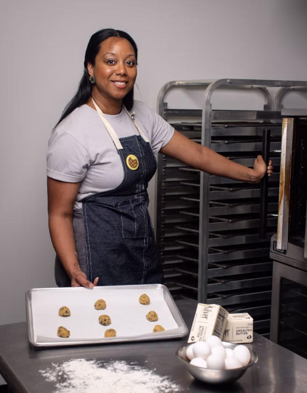 A woman holds a baking sheet of cookies in Richmond VA local bakery
