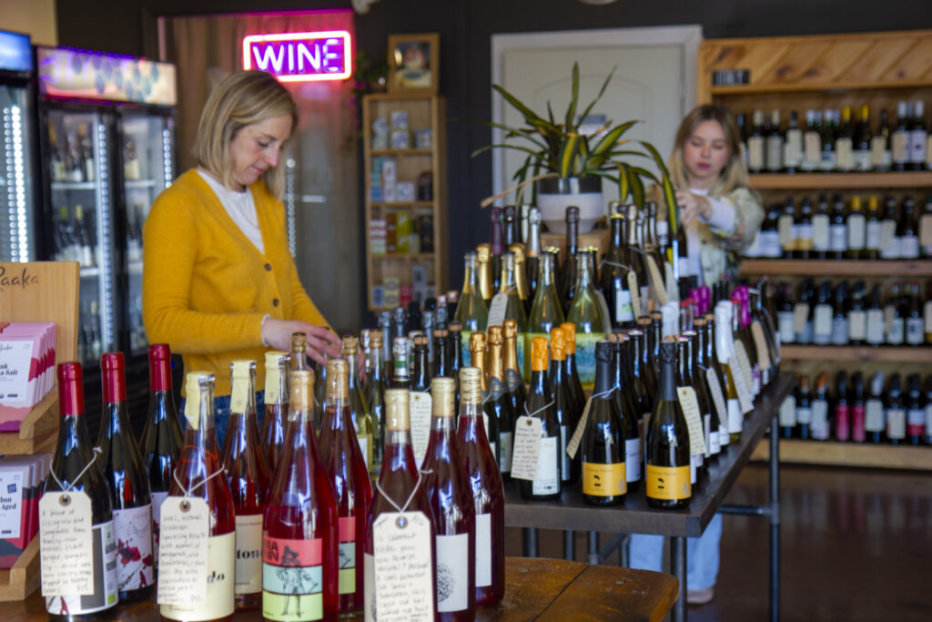 A woman in Richmond VA sorts wine bottles in her local business 