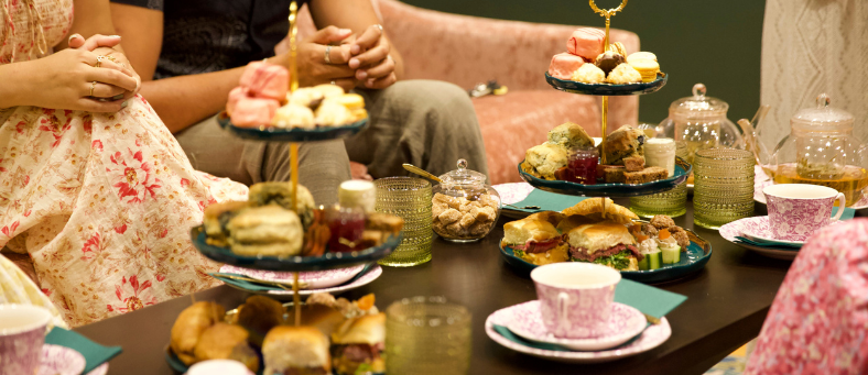 an afternoon tea table set with ladies gathered around it