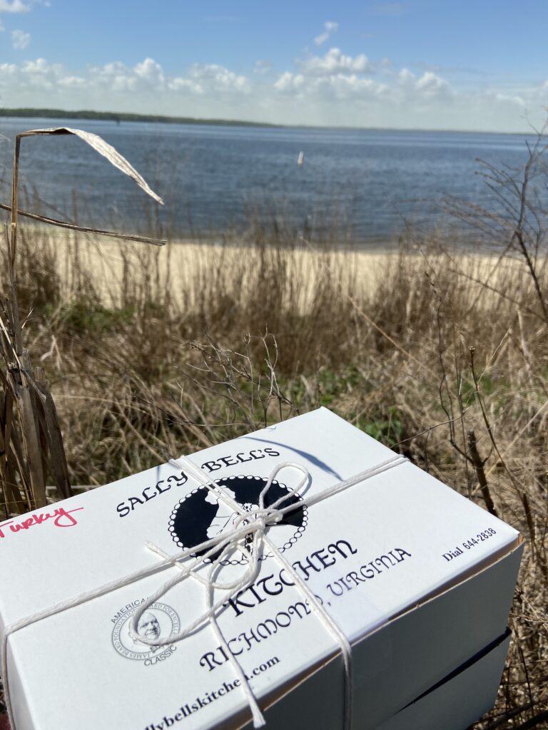 A Sally Bell's Kitchen boxed lunch with a beach behind it